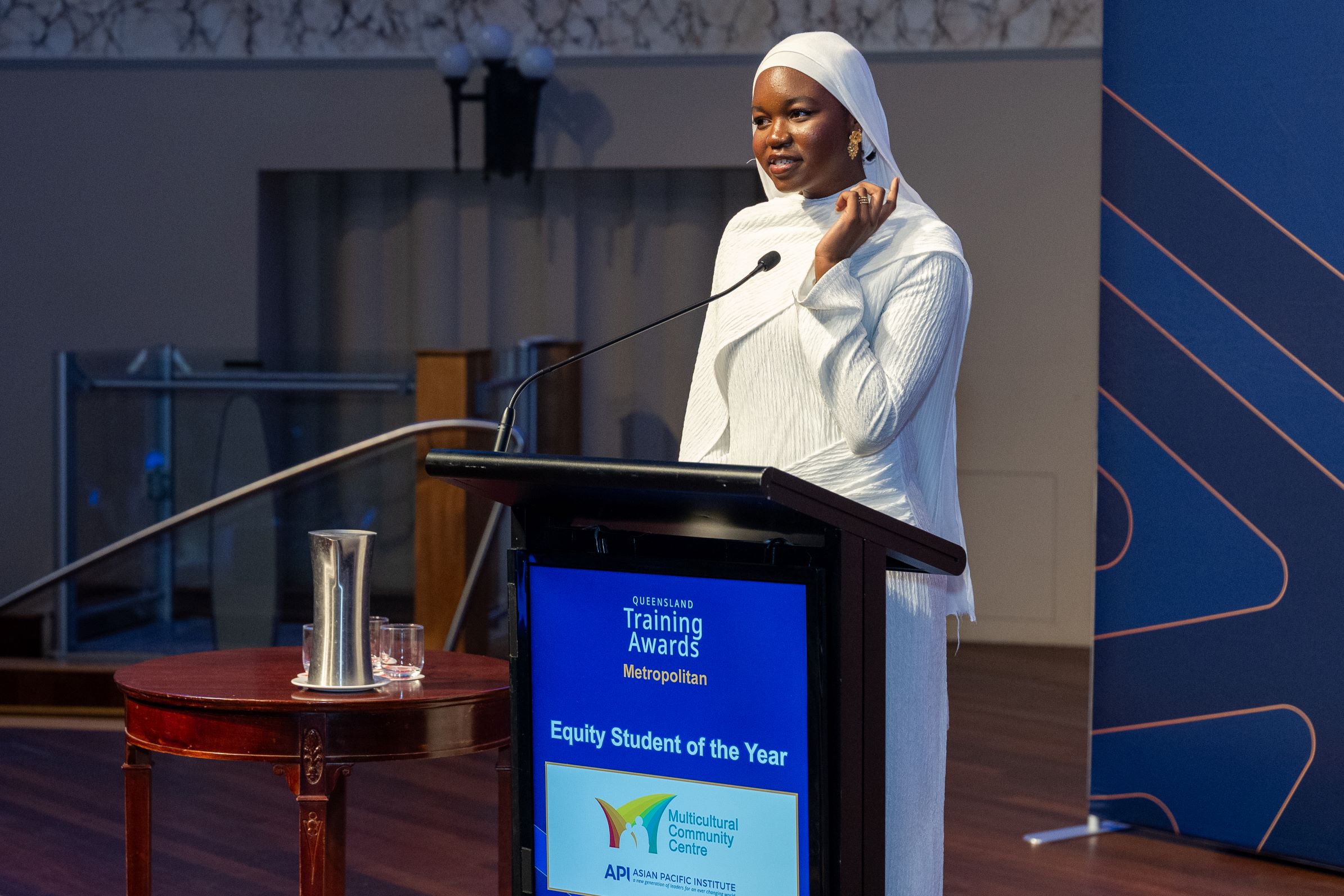 Sudanese woman wearing a white hijab delivering a speech as the Equity student of the year at the Queensland Training Awards