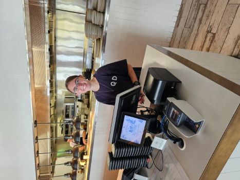 Tille working behind a cash register at The Ville.